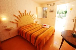 a bedroom with a bed with a sun on the wall at L'Oasi Villaggio Albergo in Favignana