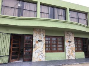 a green building with doors and windows at Chilo Hotel in Termas de Río Hondo