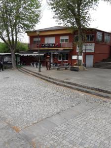 um edifício vermelho com um restaurante numa rua em A Concha em Lavacolla