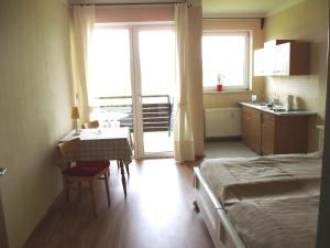 a bedroom with a bed and a table and a kitchen at Ferienwohnung Mostecky in Ferlach