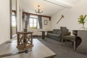 uma sala de estar com um sofá e uma mesa em Burghotel Stolpen em Stolpen