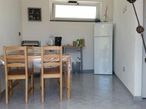 uma cozinha com uma mesa e cadeiras e um frigorífico em B&B La Costa em Pignone
