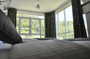 a bedroom with a bed and a large window at Forest View Lodge in Nuwara Eliya