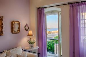 a living room with a window with purple curtains at Antouanetta Apartments in Ermoupoli