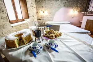 a table with a cake and a plate of cookies at Le Aie Di Postignano in Sellano