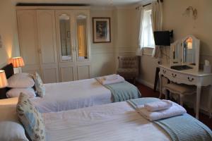 a hotel room with two beds and a desk at Old Court Hotel & Apartments in Symonds Yat