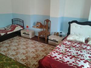 Guest house near Baku airport في باكو: غرفة نوم بسريرين وطاولة وكرسي