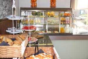 a bakery with bread and pastries on a counter at Strandhotel Dennenbos in Oostkapelle
