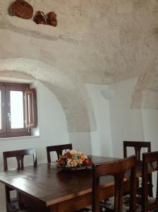 a dining room with a wooden table and chairs at I Trulli del Mulino in Locorotondo