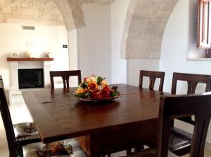 a dining room table with a bowl of flowers on it at I Trulli del Mulino in Locorotondo
