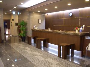 un vestíbulo de hotel con un bar con bancos en Hotel Route-Inn Aomori Chuo Inter en Aomori