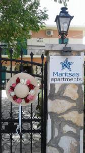 a wreath on a gate with a sign on it at Maritsas Apartments in Roda