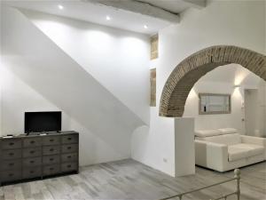 a white living room with a white couch and an archway at Mandralisca Garden in Cefalù