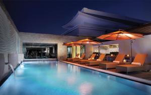 uma piscina com cadeiras e uma lareira em Asiana Hotel Dubai no Dubai