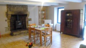 a living room with a table and a fireplace at maison a locrio in Guern