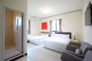 ein Hotelzimmer mit zwei Betten und einer Couch in der Unterkunft Kinmen Line In Bed and Breakfast in Jinhu