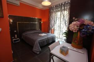 a bedroom with a bed and a table and a window at Roma Gianicolense in Rome