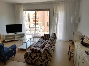 - un salon avec un canapé et une télévision dans l'établissement Apartament a la Placeta de Sant Joan 21, 3r, à Sant Feliu de Guíxols