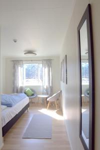 1 dormitorio con cama, escritorio y espejo en Sørvågen INN, en Sørvågen