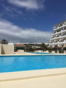 a large swimming pool next to a large building at Cozy Studio with Seaview in Costa Del Silencio
