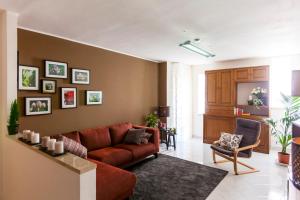 Appartamento Telese Terme في تيليسي: غرفة معيشة مع أريكة حمراء وجدار بني