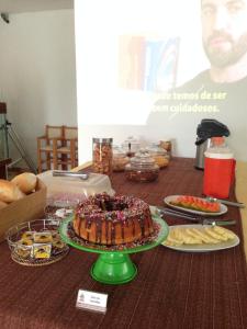 a table with a cake and other food on it at Parque Hotel Holambra in Holambra