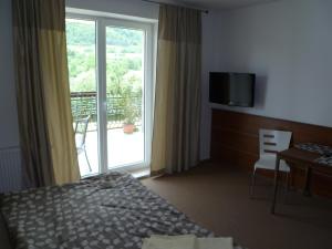 a hotel room with a bed and a large window at Horský penzión Šuštiak in Terchová