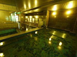 uma grande piscina de água com luzes numa casa de banho em Hotel Route-Inn Minokamo em Minokamo