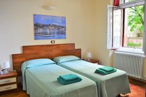 トリエステにあるCasa vacanza Tigorのベッドルーム(緑のシーツを使用したベッド2台付)
