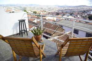 a balcony with two chairs and a view of a city at Bella Vista El Tronco in Sucre