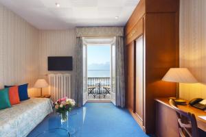 a hotel room with a bed and a view of the ocean at Golf Hotel René Capt in Montreux