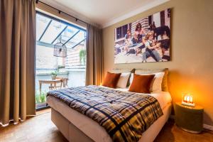 a bedroom with a bed and a large window at Aplace Antwerp boutique flats & hotel rooms in Antwerp