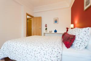 リスボンにあるTop Location Beautiful Apartmentのベッドルーム(白いベッド1台、赤い枕付)