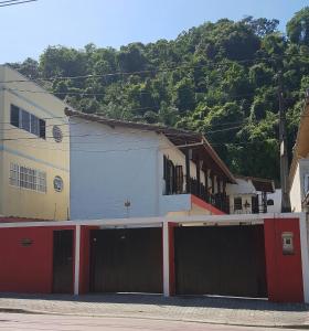 a white and red building with two garage doors at Suites Nativa in Ubatuba