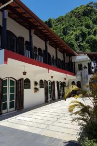 a white building with a balcony on top of it at Suites Nativa in Ubatuba +13 photos