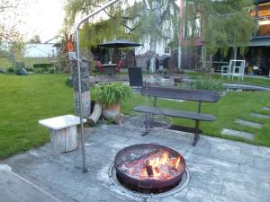 a fire pit in a yard with a table and a chair at Donautaler Wohlfühloase in Gundelfingen