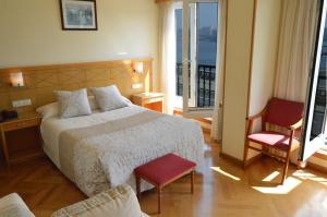 ein Hotelzimmer mit einem Bett und zwei Stühlen in der Unterkunft Hotel Cristal 2 in A Coruña