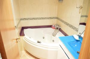 baño con bañera blanca y lavamanos azul en Hotel Cristal 2, en A Coruña