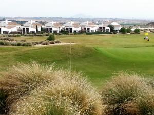 una vista de un campo de golf con casas en el fondo en Apartamento Valle Golf Resort, en Baños y Mendigo