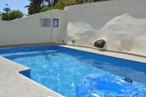 una piscina con una gran piscina azul en Anemomilos Villa en Firostefani