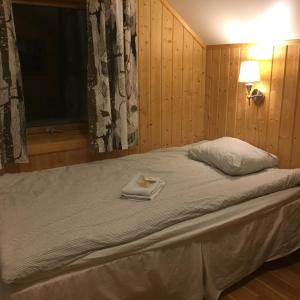 Un dormitorio con una cama con una toalla. en Birk Husky - guesthouse & cabins, en Svanvik