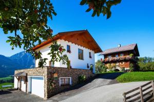 ein großes weißes Haus mit rotem Dach in der Unterkunft Ferienwohnung Bognerhof in Sankt Veit im Pongau