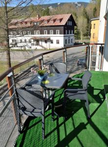 a patio with a table and chairs on a balcony at Apartmán Rokytka 205 in Rokytnice nad Jizerou