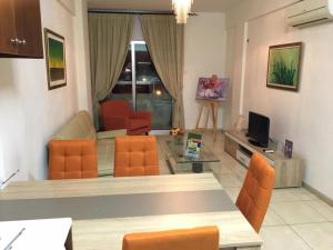 sala de estar con mesa y sillas de color naranja en Marina Apartments 211 en Lárnaca