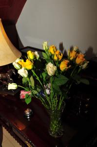 um vaso cheio de flores amarelas e brancas sobre uma mesa em Killererin House B&B em Letterkenny