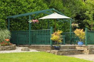 a green gazebo with a table and an umbrella at Killererin House B&B in Letterkenny