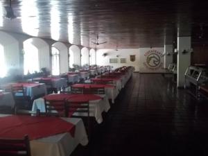 a dining room with red and white tables and chairs at Apartamento Cavalinho Branco 501 in Águas de Lindoia