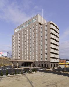 een groot gebouw met een bord erop bij Hotel Route-Inn Sendaiizumi Inter in Sendai