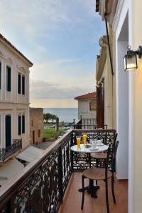 balcón con mesa, sillas y vistas al océano en Elia Palazzo Hotel, en La Canea