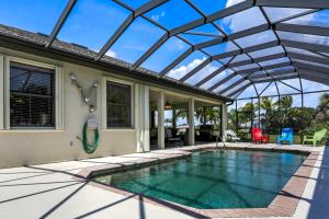 a swimming pool with a glass roof on a house at Villa Maxine in Cape Coral